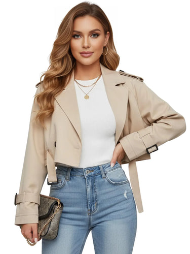 Woman wearing a beige cropped trench coat, white top, and blue jeans on a white background